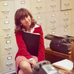 Photo of Mary Braden sitting at her desk in a congressional office in the 1970s.